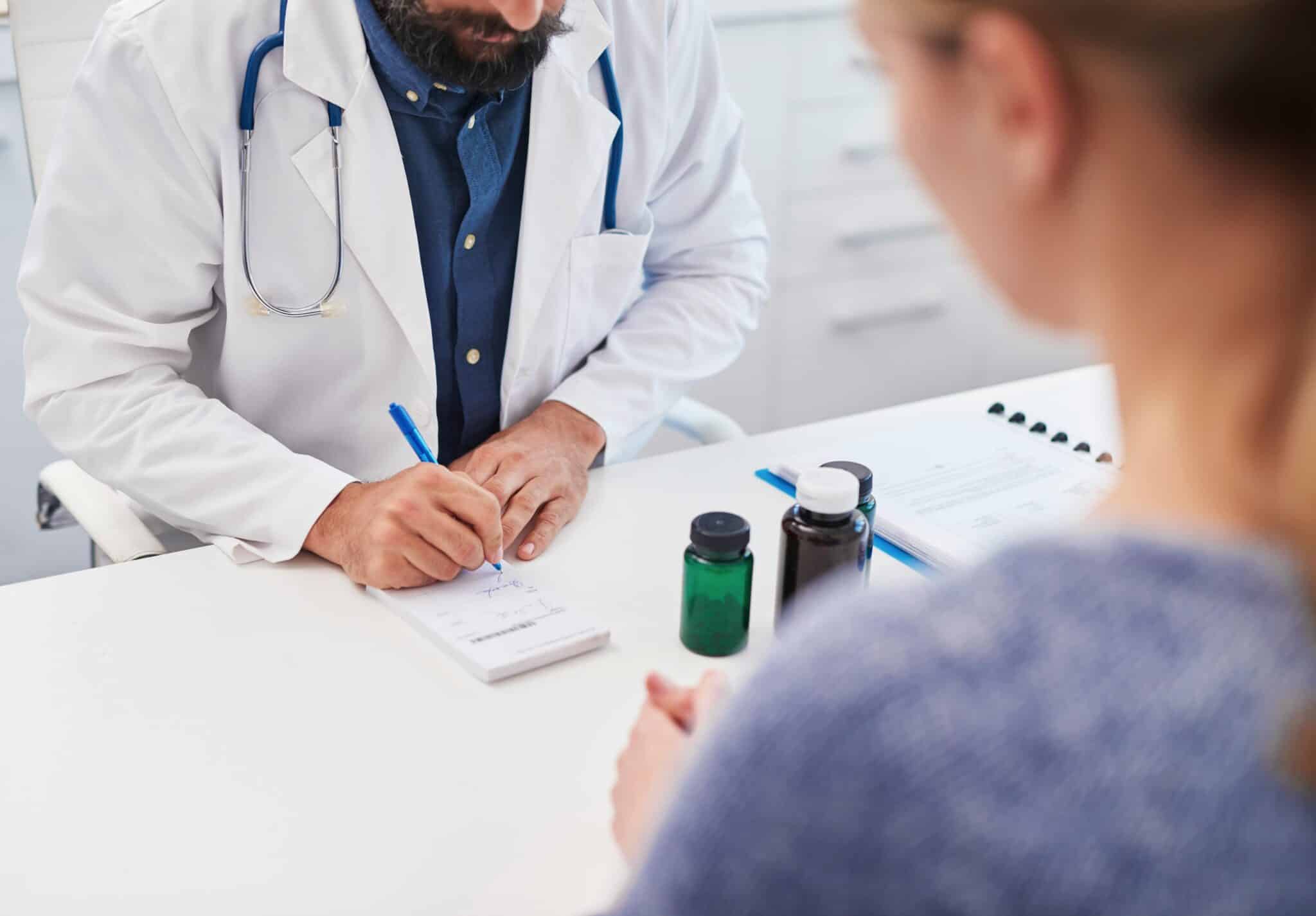 Doctor writing a prescription for a patient