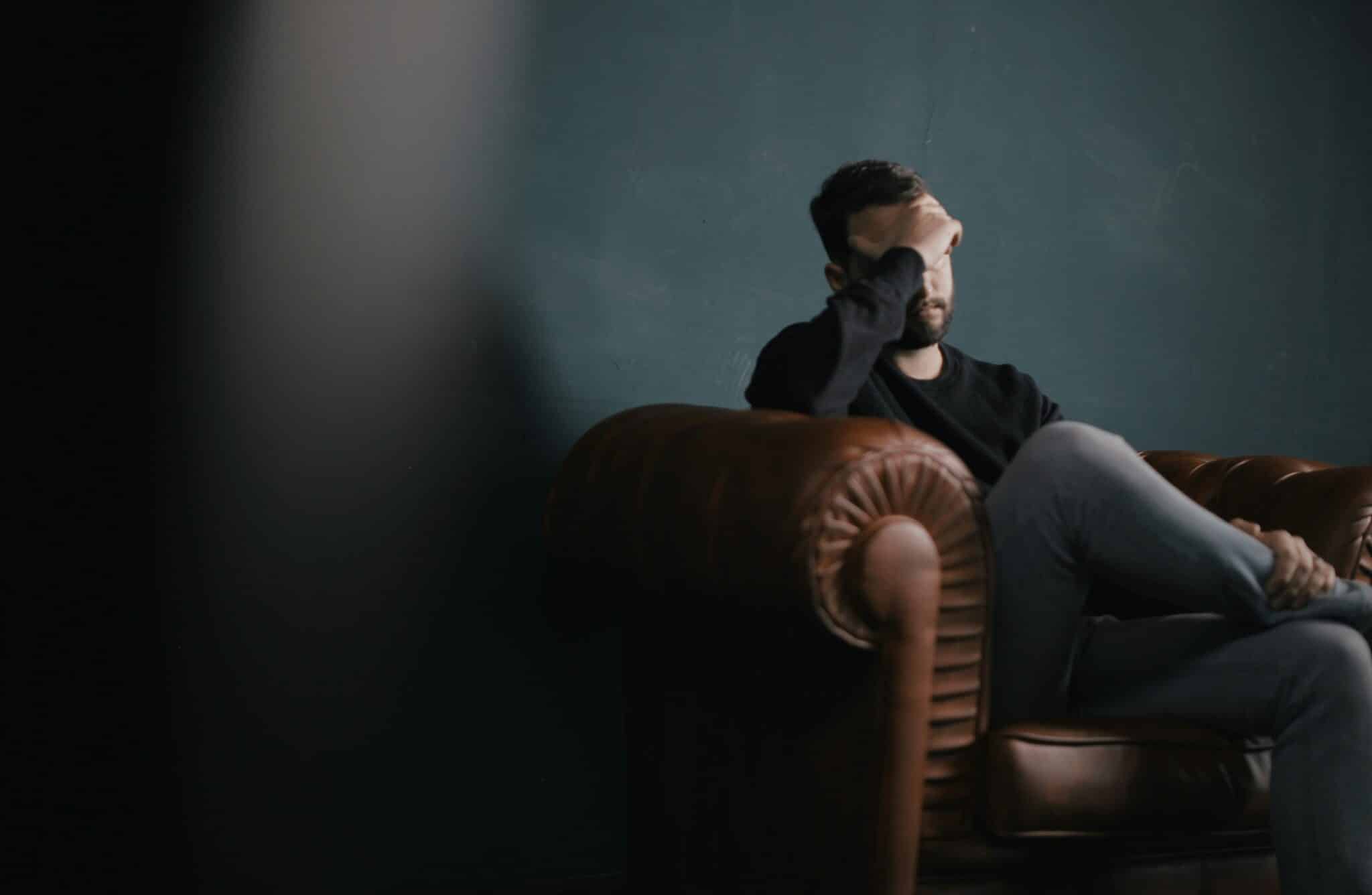 Man sitting on couch having a migraine