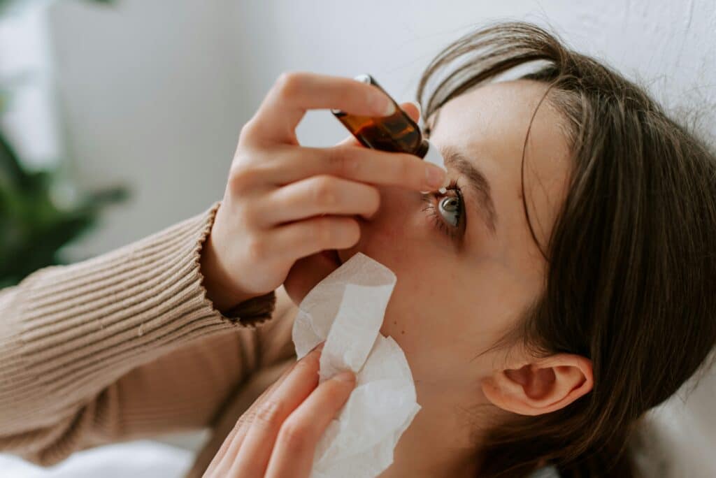Woman instilling eye drops